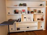 a white book shelf with books on it in a room
