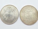 two silver coins, one of which has a woman and one of which is a man