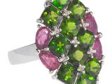 un gros plan d'une bague verte et rose sur fond blanc