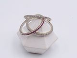 two white gold and pink sapphire rings on top of a white marble block