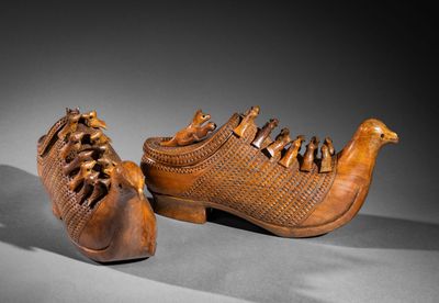 pair of carved shoes with a bird on the sole