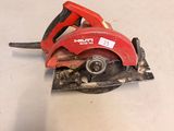 a red circular saw sitting on top of a white table