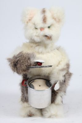 une peluche qui tient une casserole et une cuillère