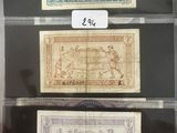 Trois types de monnaies différents sont exposés dans une vitrine.