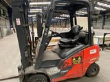 un chariot élévateur rouge garé dans un entrepôt