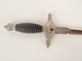 a silver sword with a red stone on it