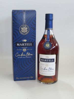 une bouteille de cognac Martelli dans son coffret, posée sur une table