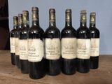 several bottles of wine are lined up on a wooden table