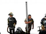 four figurines of firemen standing next to each other