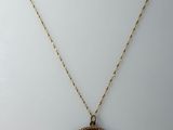 un collier en or avec une pièce de monnaie sur une chaîne