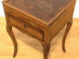 a small wooden table with a glass top on a hard wood floor