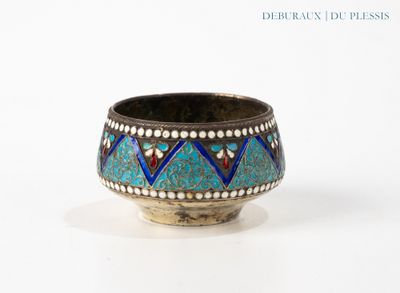 an old silver bowl with a blue and red design on it