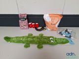 a stuffed alligator sitting on a table next to a bag of food