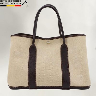 a brown and white tote bag sitting on top of a white table