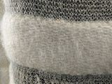 close up of a knitted sweater with a hole in the middle of it