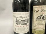 three bottles of wine are lined up on a white surface
