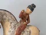 a figurine of a man sitting on a horse