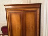 a wooden cabinet in the corner of a room with a lamp on top of it