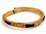 an image of a gold and black bracelet on a white surface