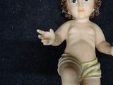 a baby doll that is sitting on a black surface