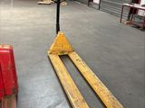 a forklift in a warehouse with a red object in the foreground