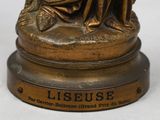 bronze statue of a woman sitting on a bench with a dog