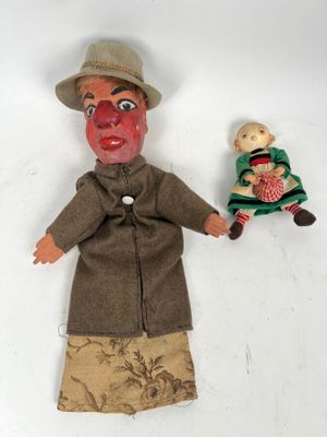 une poupée avec un visage de clown et une poupée sur laquelle se trouve une autre poupée