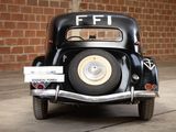 a black car parked in front of a brick wall