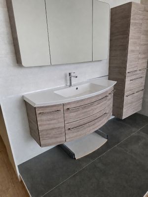 une salle de bains équipée d'un lavabo, d'un miroir et de placards