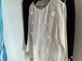 a white shirt hanging on a clothes rack in a room