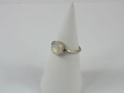 un gros plan d'une bague sertie d'une pierre blanche