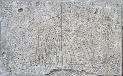 une plaque en pierre sur laquelle est sculpté un bateau