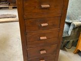 a tall wooden chest of drawers in a room