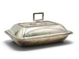 an old silver covered dish with a handle on a white background