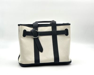 a white and black tote bag sitting on top of a white table