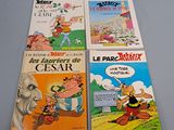 four cartoon books are lined up on a blue surface