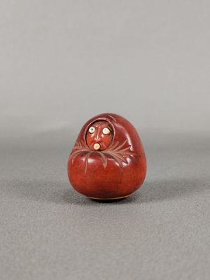 une petite figurine rouge et blanche posée sur une table