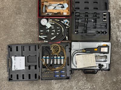 de nombreux outils différents rangés dans une mallette posée par terre