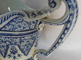 a blue and white pitcher with a handle on a table