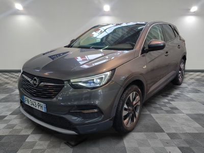 Le SUV Opel gris est garé dans une pièce au sol carrelé.