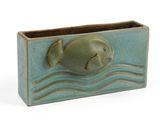 un vase vert contenant un poisson, sur fond blanc