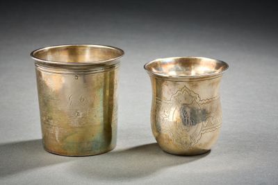 two silver cups sitting next to each other on a table