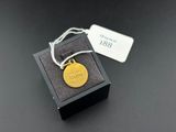 an image of a gold coin in a black box with a tag on it