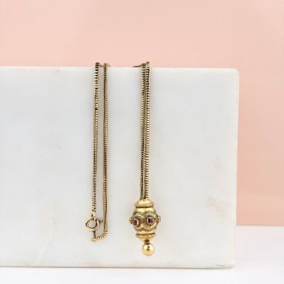 une paire de boucles d'oreilles plaquées or posées sur un bloc de marbre
