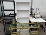 many different chairs and tables in a warehouse area