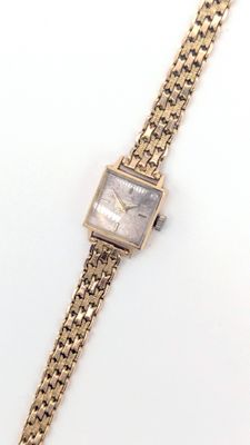 gros plan d'une montre-bracelet entourée d'une chaîne