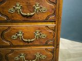 an old wooden chest of drawers with brass handles on top of it