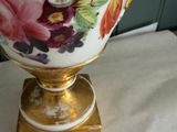 a vase with flowers painted on it sitting on a table