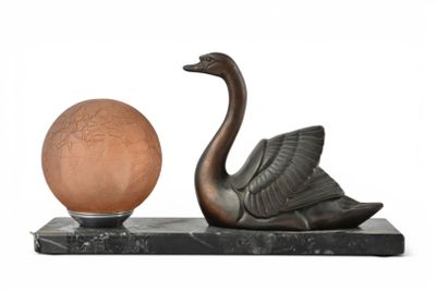 une statue représentant un cygne et une boule, posée sur un socle en marbre