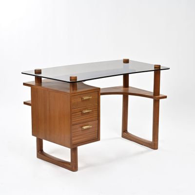 une photo d'un bureau avec un plateau en verre et des pieds en bois